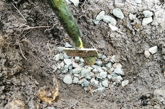 ポールを地中に埋めて固定するため、穴掘りして砂利を敷く