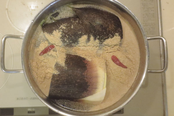 タケノコのあく抜き　鍋に水、米ぬか、鷹の爪を入れて煮る