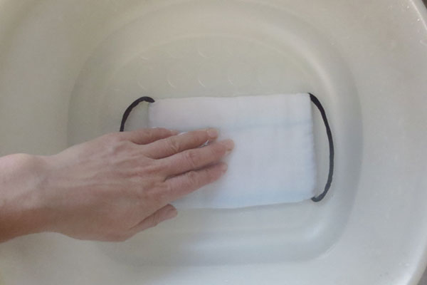 布マスクを医療用洗剤を溶かした水で押し洗いする。